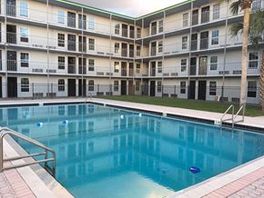 Kissimmee apartment for rent - a large swimming pool in front of an apartment building