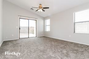Avondale house for rent - A spacious room with a ceiling fan and sliding glass doors.