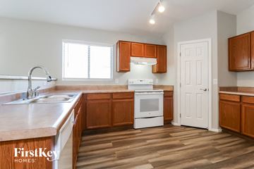 Avondale house for rent - A kitchen with wooden cabinets and a white oven.