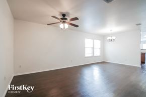 Burleson house for rent - an empty living room with white walls and a ceiling fan