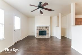 Burleson house for rent - a living room with a fireplace and a ceiling fan