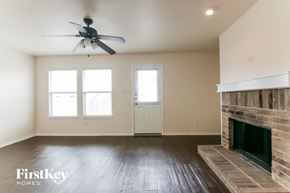Burleson house for rent - a living room with a fireplace and a ceiling fan