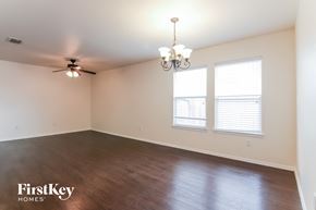 Burleson house for rent - an empty living room with wood floors and a ceiling fan
