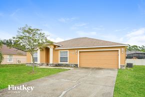 Kissimmee house for rent - a yellow house with a driveway and a garage door