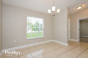 Kissimmee house for rent - a dining room with a large window and a tiled floor