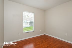 Kissimmee house for rent - a bedroom with wood floors and a window