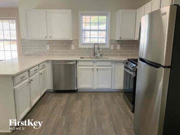 Snellville house for rent - a kitchen with white cabinets and a stainless steel refrigerator