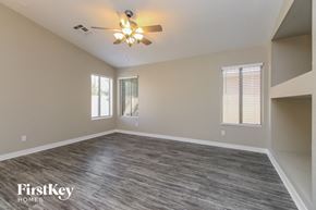 Phoenix house for rent - an empty living room with a ceiling fan and window