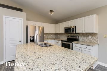 Phoenix house for rent - a kitchen with white cabinets and a granite counter top