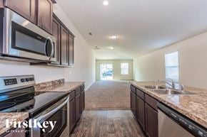 Jacksonville house for rent - A kitchen with a stove top oven, microwave, and dishwasher.