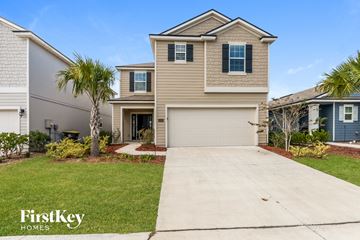 Jacksonville house for rent - a beige house with a garage door and a driveway