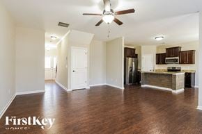 Ball Ground house for rent - A spacious room with a ceiling fan and wooden flooring.