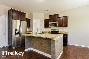 Ball Ground house for rent - A kitchen with wooden cabinets and a granite countertop.