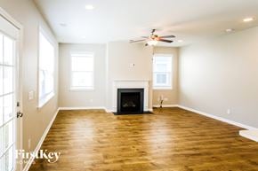 Summerville house for rent - A spacious living room with a fireplace and wooden floors.