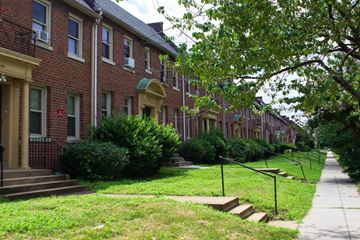 Washington apartment for rent - A row of red brick houses with green lawns in front.