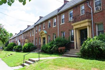 Washington apartment for rent - A row of red brick houses with green lawns in front.
