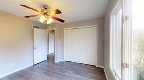Crown Point apartment for rent - an empty living room with a ceiling fan and white closets