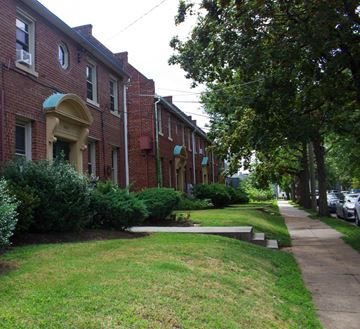 Washington apartment for rent - A row of red brick houses with green lawns in front.