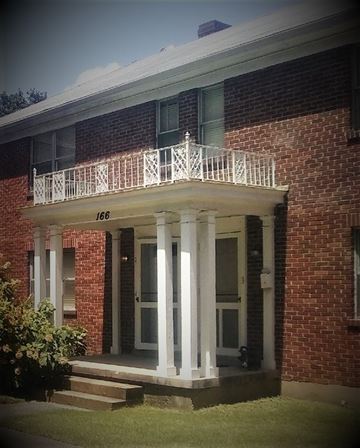 Memphis apartment for rent - A red brick house with a white porch and a balcony.