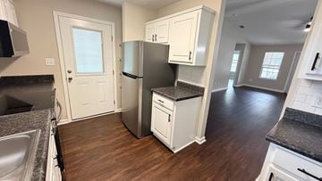 Moultrie apartment for rent - A kitchen with white cabinets and a black countertop.
