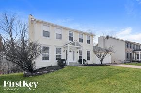 Ballwin house for rent - A white two-story house with a black front door and a small front yard.