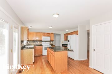 Ballwin house for rent - A kitchen with wooden cabinets and a white refrigerator.
