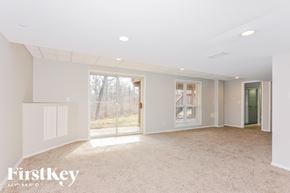 Ballwin house for rent - A spacious, empty room with a carpeted floor and white walls.