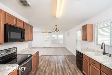 San Antonio house for rent - a kitchen and living room with wood flooring and black appliances