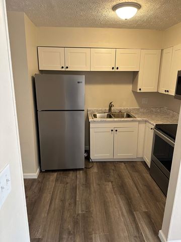 Columbus apartment for rent - a kitchen with white cabinets and a stainless steel refrigerator
