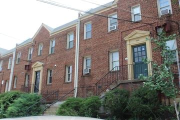 Washington apartment for rent - A red brick building with a yellow door and windows.