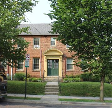 Washington apartment for rent - A red brick house with a green door and a no parking sign in front.