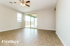 Buckeye house for rent - A spacious room with a ceiling fan and sliding glass doors.