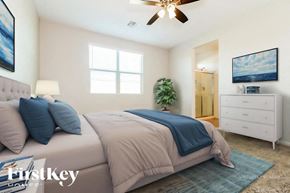 Buckeye house for rent - A bedroom with a bed, dresser, and ceiling fan.