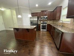 Buford house for rent - a large kitchen with stainless steel appliances and wood floors