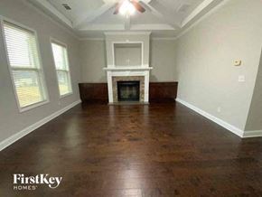 Buford house for rent - an empty living room with a fireplace and wooden floors