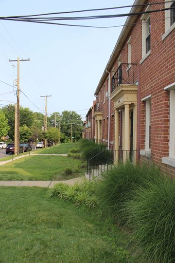 Washington apartment for rent - A row of red brick houses with green grass in front.