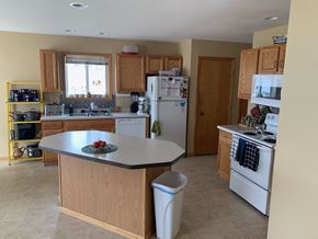 Eau Claire apartment for rent - a kitchen with white appliances and wooden cabinets