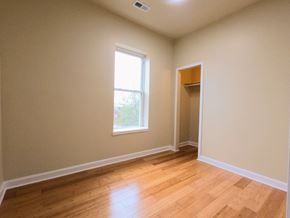 Chicago apartment for rent - an empty living room with a window and wooden floors