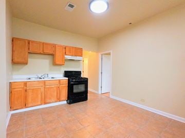 Chicago apartment for rent - a kitchen with wood cabinets and a black stove