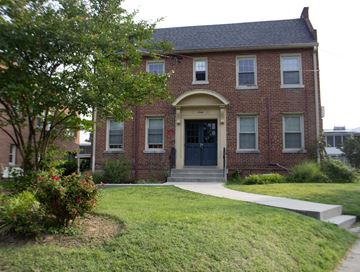 Washington apartment for rent - A red brick house with a black front door and a small porch.