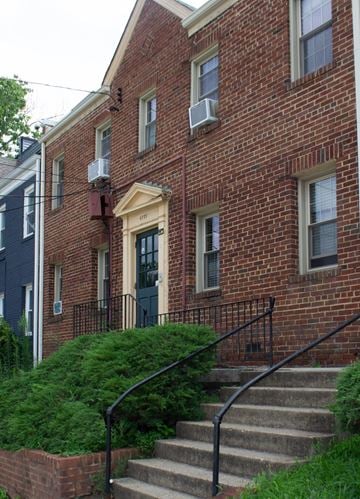 Washington apartment for rent - A red brick house with a black iron railing.
