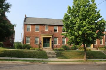 Washington apartment for rent - A red brick house with a green tree in front.