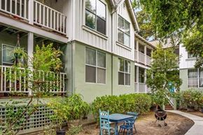 Santa Cruz apartment for rent - A green building with a balcony and a table and chairs in front.
