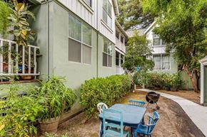 Santa Cruz apartment for rent - A patio with a table and chairs is surrounded by green plants.