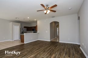 Valrico house for rent - A spacious room with a wooden floor and a ceiling fan.