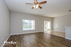 Valrico house for rent - A spacious room with a ceiling fan and wooden flooring.