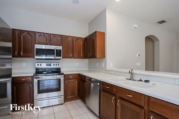 Valrico house for rent - A kitchen with brown cabinets and stainless steel appliances.
