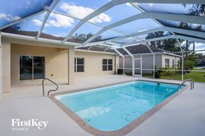 Valrico house for rent - A swimming pool is in the middle of a patio area.