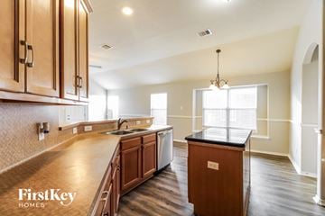 Kingwood house for rent - a kitchen with wooden cabinets and a counter top and a sink