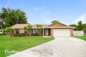Kissimmee house for rent - a house with a driveway and a garage door